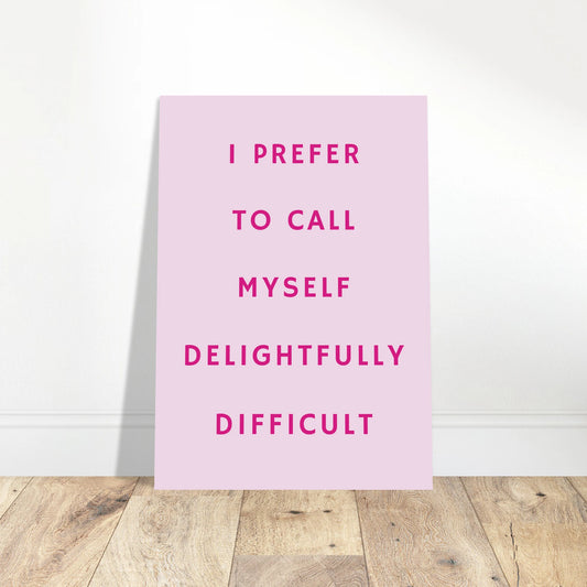 Pink typography art print reading “I Prefer To Call Myself Delightfully Difficult” in a minimalist framed wall setting